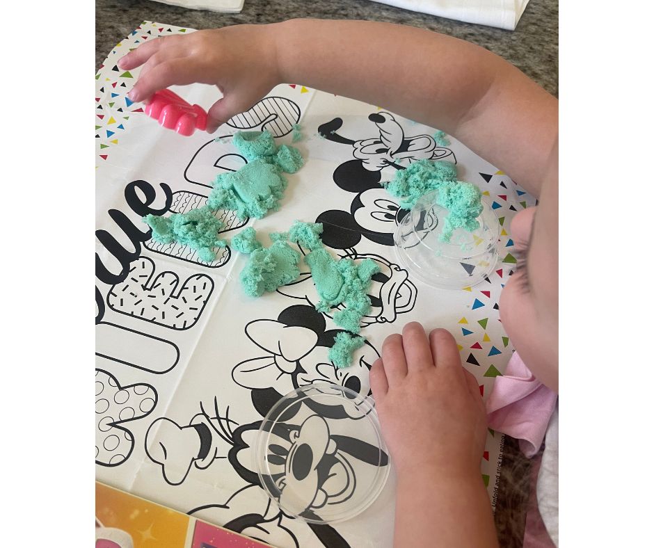 play sand on a coloring mat, toddler at a restaurant